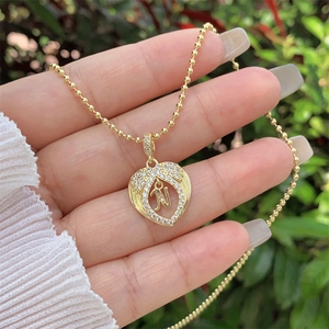 Close-up of 18K gold plated heart pendant with zircon letter N and beaded chain