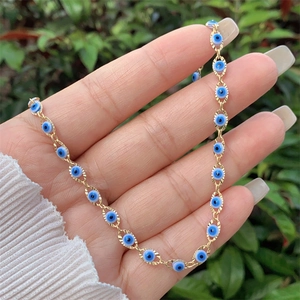 Detailed close-up of 18K gold plated evil eye necklace and bracelet with blue beads