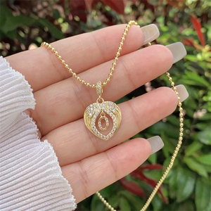 Close-up of 18K gold plated bead chain necklace with heart pendant and zircon letter O
