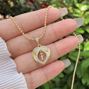 Detailed close-up of 18K gold heart pendant necklace with micro-paved zircons and letter P
