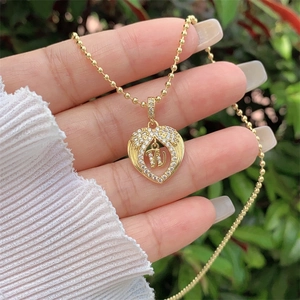 Close-up of heart-shaped 18K gold plated pendant necklace with letter W and cubic zirconia