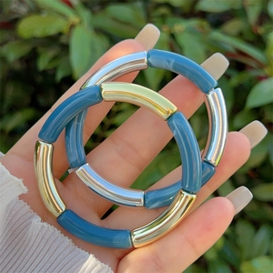 Detail of blue resin and mixed metal segment bracelets shown in an outdoor setting