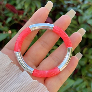 Close-up of bamboo-style elastic bracelet with silver metal and marbled pink resin tubes