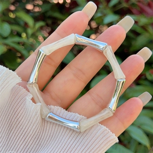 Dettaglio ravvicinato dei segmenti in resina crema e argento a forma di bambù sul bracciale
