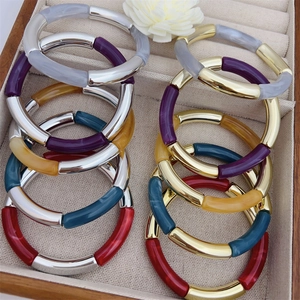 Colorful resin bamboo joint bracelets with metal segments in a beige jewelry box
