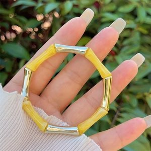 Dettaglio del bracciale a maglie di bambù in resina gialla e metallo argentato lucido