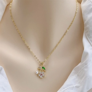 18K vergoldete Blumenhalskette mit Zirkonia und Perle an einem weiblichen Modell