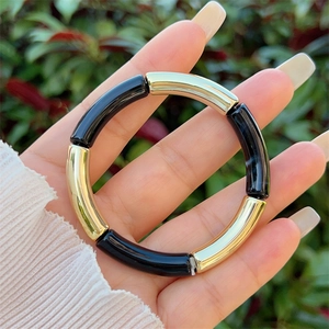 Detail of bamboo-style resin bracelet with alternating gold polished and black tubes