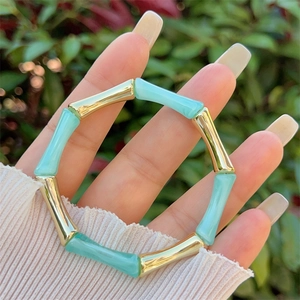 Dettaglio del bracciale stile bambù in resina blu chiaro e metallo dorato regolabile