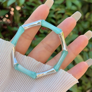 Dettaglio del bracciale stile bambù argentato con resina blu traslucida sul polso