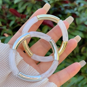 Bamboo-style resin bangles with gold and silver metal tubes in minimalist marble design