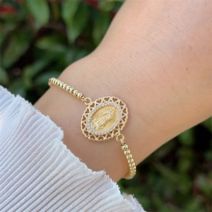 Detail of 18K gold-plated beaded bracelet with Virgin Mary pendant and zircon stones