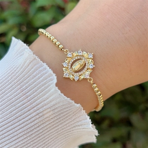 Λεπτομέρεια από επιχρυσωμένο βραχιόλι 18K με μενταγιόν Παναγία και ζιργκόν πέτρες σε χρυσό
