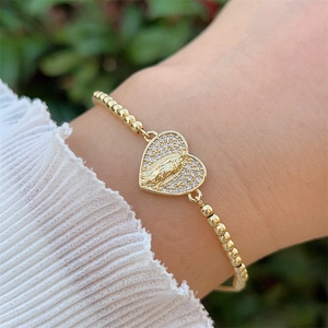 Detailaufnahme des 18K vergoldeten Perlenarmbandes mit einem Herzanhänger der Jungfrau Maria