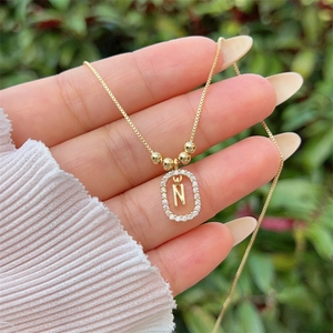 Detail of 18K gold-plated letter N pendant featuring sparkling pave-set cubic zirconia