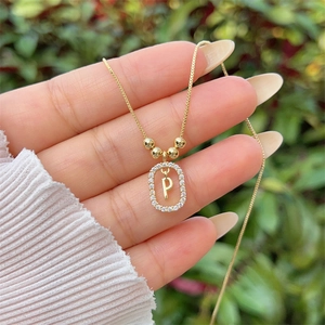 Macro detail of 18K gold plated letter P pendant with sparkling cubic zirconia inlay