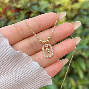 Detailed macro of a gold 18K plated letter R pendant with sparkling zircon gemstones
