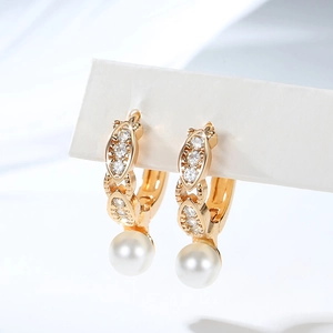Detail of gold-plated hoop earrings with micro-set zircons and a white round pearl drop