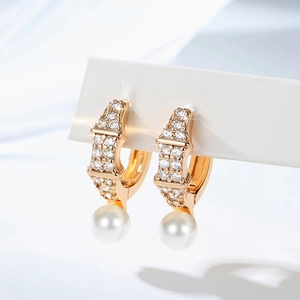 Detailed view of gold plated pearl earrings with sparkling pavé cubic zirconia setting