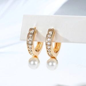 Macro shot of 18K gold plated hoop earrings with zircon pavé and a round white pearl
