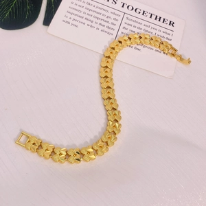 Détail d'un bracelet plaqué or 24K avec maillons en forme de cœur sur fond blanc