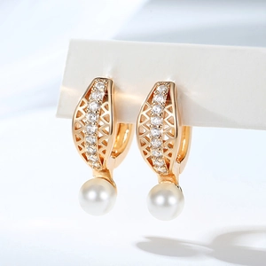Detailed macro view of gold-plated hoop earrings with micro zircons and white pearls