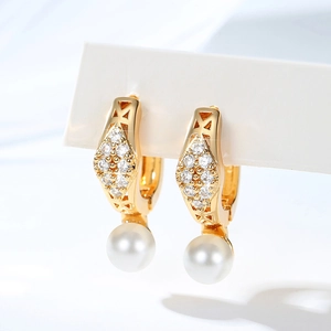 Detailed view of gold-plated earrings with pavé zircons and white round pearls