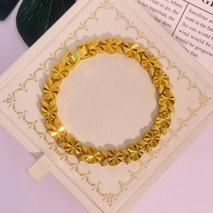 Gros plan d'un bracelet doré en forme de cœur avec des textures mates et rayonnantes