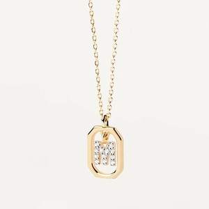 Macro view of gold octagon pendant with letter M zircon inlay on a minimalist necklace