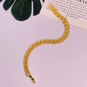 Détail macro du bracelet plaqué or 24 carats avec maillons à motif étoilé ondulé