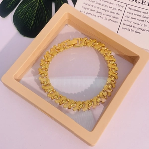 Gros plan du bracelet plaqué or 24K montrant des vagues et des détails gravés