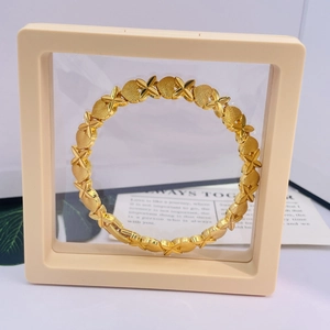 Détail du bracelet plaqué or 24K avec cœurs mats et maillons polis sur un support