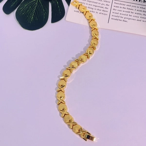 Gros plan détaillé du bracelet plaqué or 24 carats avec anneaux mats et maillons en X