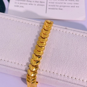 Détail d'un bracelet à maillons cœur plaqué or 24K présenté dans son coffret cadeau