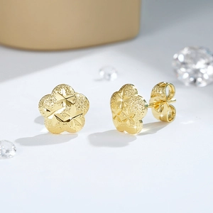 Macro di orecchini a fiore placcati oro 18K con finitura opaca e dettagli incisi