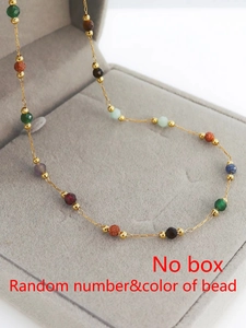 Detalle de una tobillera de cadena dorada con mezcla aleatoria de piedras naturales