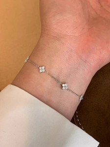 Vista dettagliata del bracciale a quadrifoglio in argento con zirconi al polso