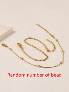 Detail of gold double-layer anklet set with twist chain and beaded snake chain