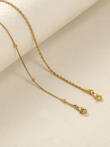 Detail of golden stainless steel twist rope and beaded snake chain anklet set with lobster clasps