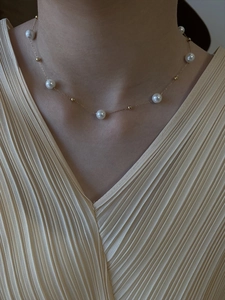 Nahaufnahme einer eleganten Perlen- und Goldperlenkette, getragen von einem Modell