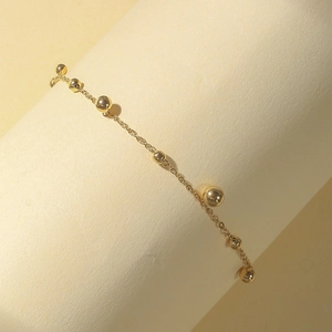Minimalistisches goldfarbenes Edelstahl-Fußkettchen mit polierten Perlen und Quasten