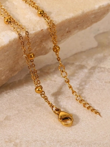 Detail der Gold-Fußkette mit Karabinerverschluss und verstellbarer Verlängerung