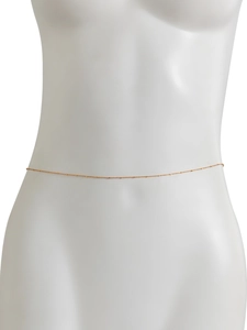 Detailed view of gold satellite chain body jewelry with small beads on a mannequin