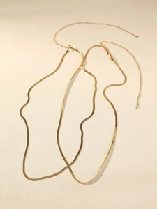 Detail of flat golden snake chain belt with lobster clasp and adjustable extension link