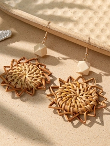 Close-up of bohemian sunflower woven rattan earrings with natural wooden beads