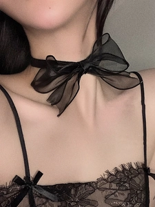 Detailaufnahme eines schwarzen Schleifen-Chokers aus Seide mit Schichten aus Organza