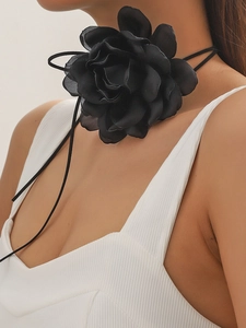 Detail of elegant black oversized fabric flower choker with adjustable lace-up ties