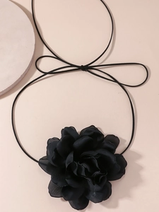 Detailed close-up of a large black fabric flower choker necklace for party wear