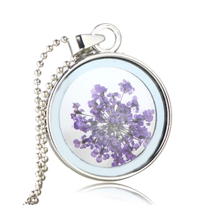 Dettaglio della collana tonda argento con veri fiori secchi viola nel ciondolo