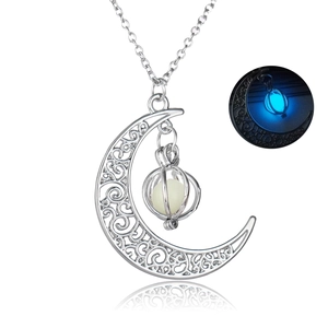 Close-up of luminous moon pumpkin pendant with filigree pattern glowing in the dark